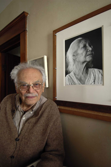 Milton Rogovin at home with one of his photographs, 2004. © Robert Hirsch
